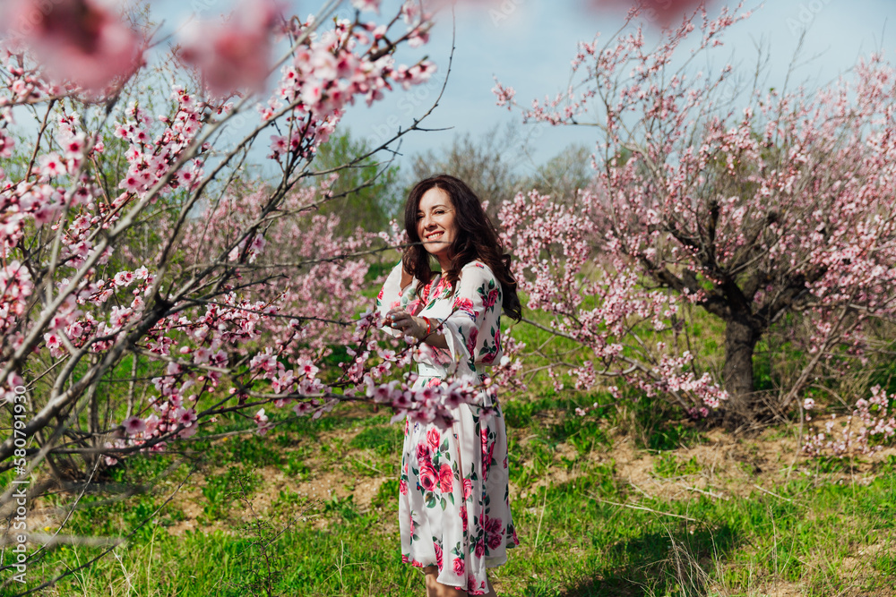 woman near pink flowering trees in peach garden nature spring woman near pink flowering trees in peach garden nature spring