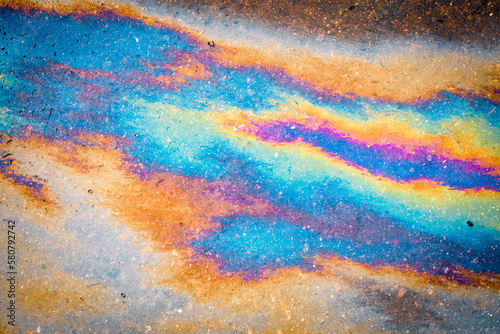 Background texture of oil spill on dark asphalt, parking lot