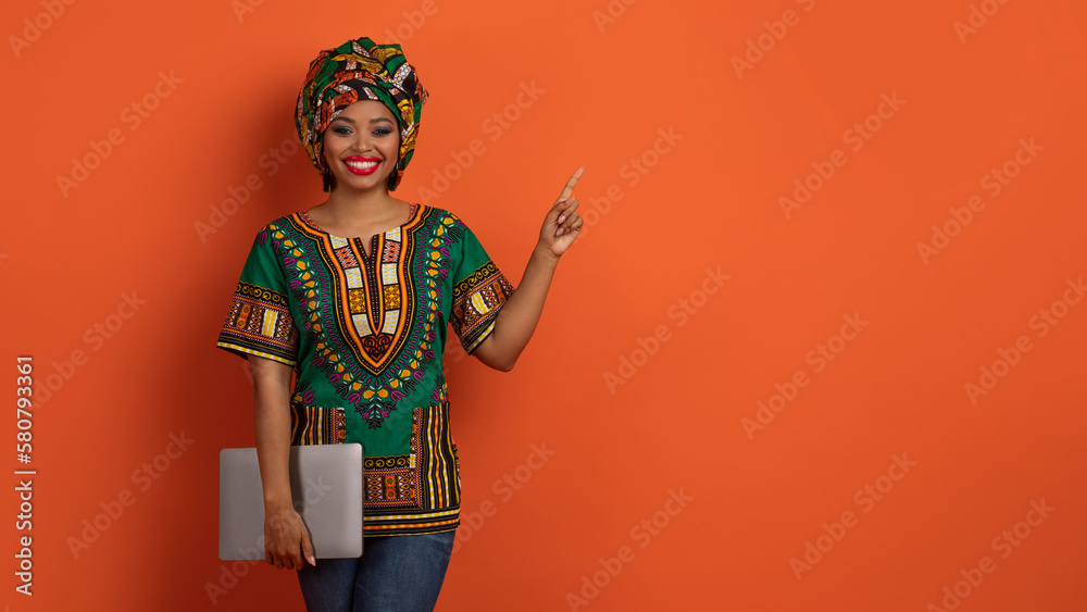 Fototapeta premium Beautiful african woman freelancer posing with laptop, copy space