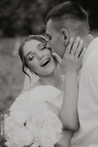 Beautiful wedding couple. the groom kisses the bride on the forehead. Happy wedding photography of bride and groom at wedding ceremony.