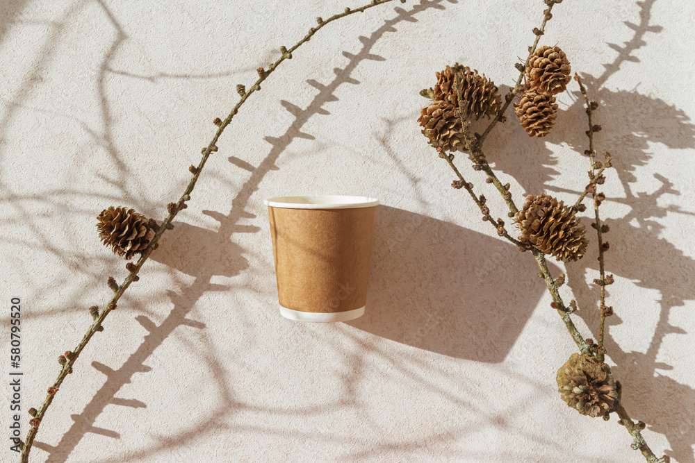 Eco friendly craft paper cup on pastel background with branch with cone ...