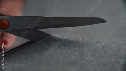Female using scissors and cutting material fabric pieces