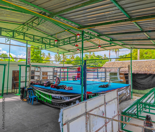 Outdoors boxing ring used for Muay Thai, Kick Boxing and MMA Training in Koh Phangan, Thailand. With leather gloves placed on the ground