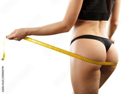 Woman with slim body measuring her waistline. Healthy weight concept.