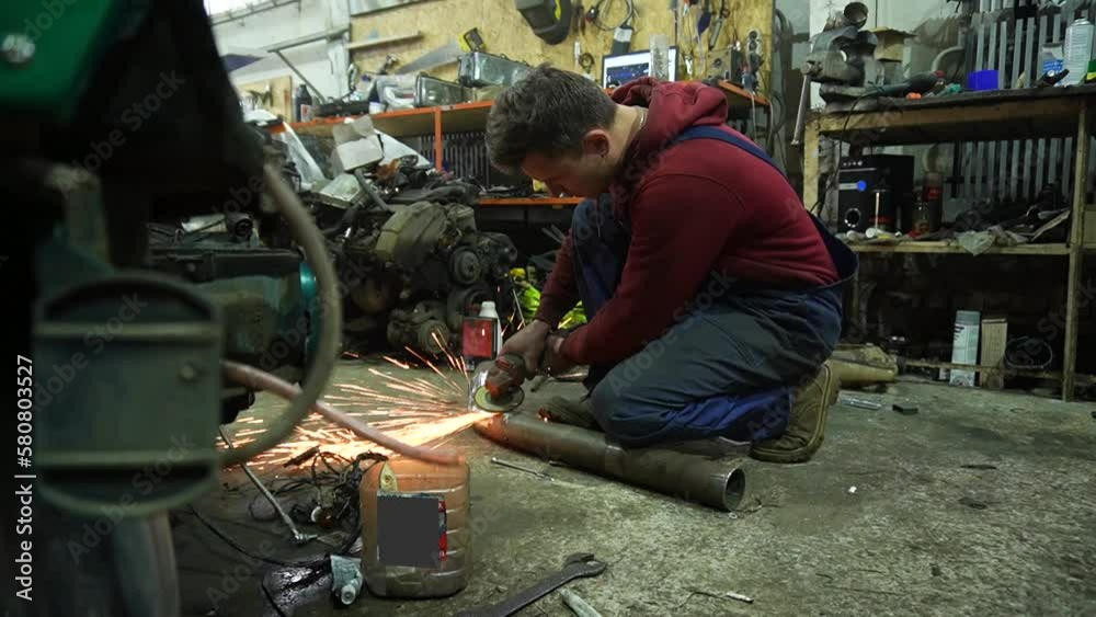 the mechanic performs cleaning work on the custom exhaust manifold and intake system for the turbo engine the mechanic performs cleaning work on the custom exhaust manifold and intake system for the turbo engine