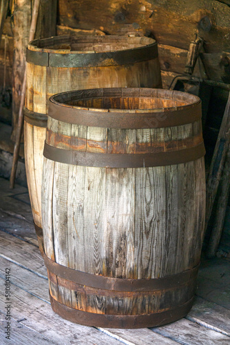 Old wooden barrels with iron rims for food storage. © lizaveta25