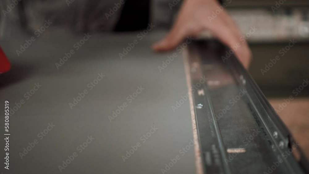 Power electric screwdriver. Carpenter working with a hand tool on the work bench. Closeup view. Carpenter drills a hole with an electrical drill.