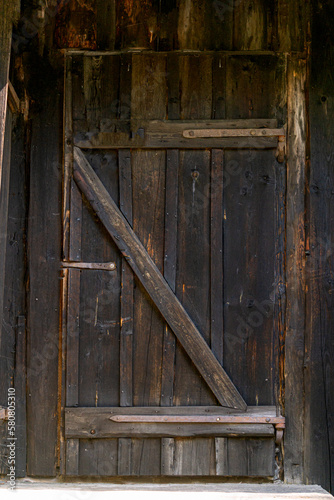 An old homemade massive wooden door, a fragment of an old estate.