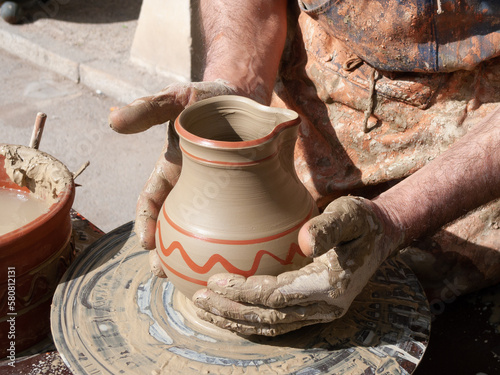 Un alfarero trabajando con sus manos sobre una vasija. photo
