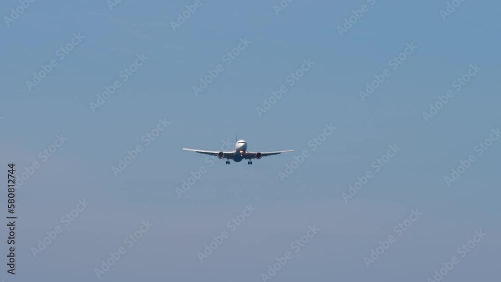 Unrecognizable passenger plane approaching to land, view from below. Concept tourism and travel Unrecognizable passenger plane approaching to land, view from below. Concept tourism and travel