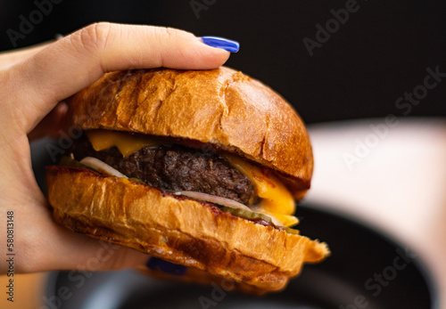 Large and juicy burger with cutlet cooked in fast food restaurant.