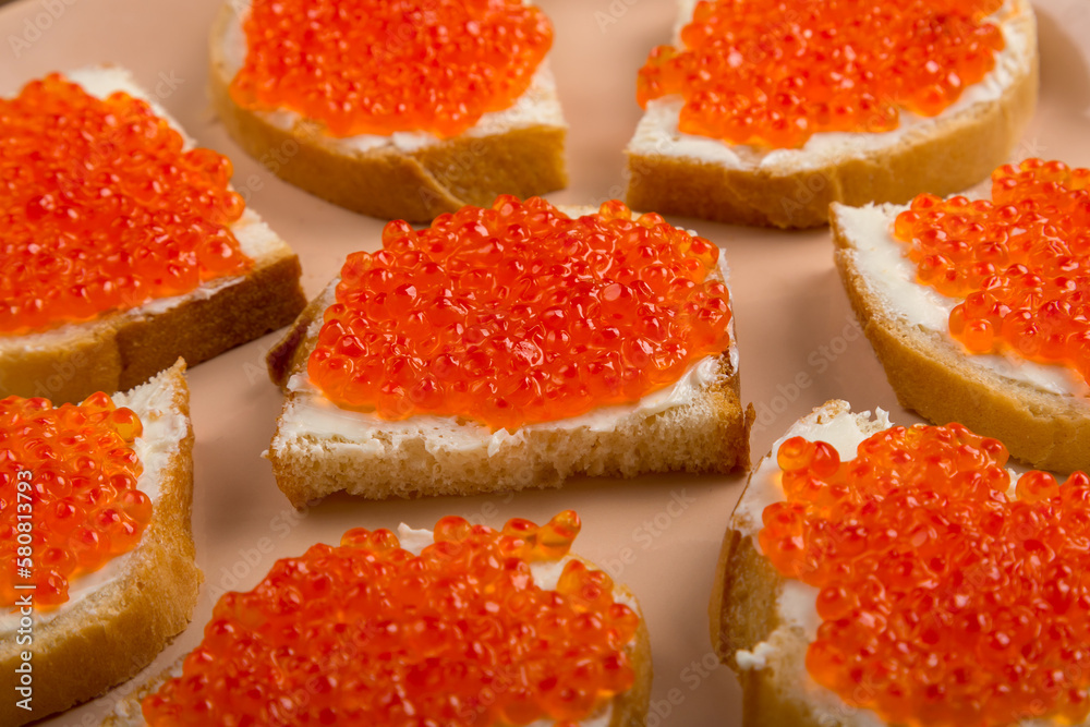 Canape with red caviar in butter on a plate.close-up. Canape with red caviar in butter on a plate.close-up.