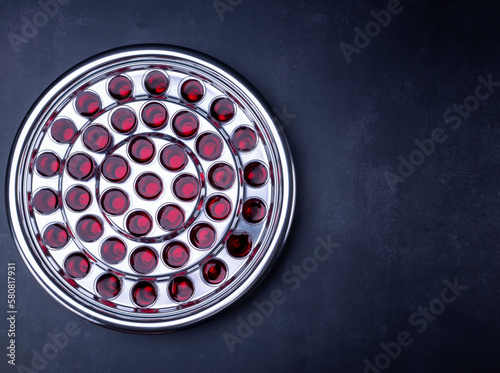 Communion glass cups with wine the symbol of Jesus Christ blood on black background