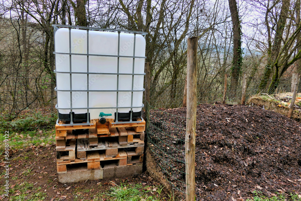 Large reinforced plastic water tank installed in a vegetable garden to