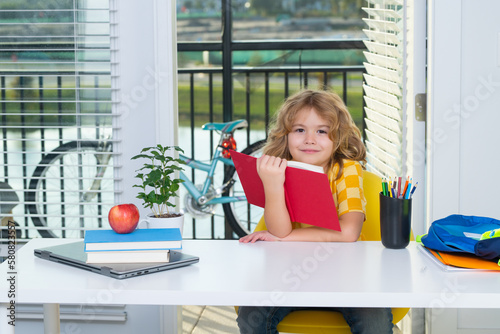 School kid reading book. Nerd school kid doing homework at home. Clever child from elementary school with book. Smart genius intelligence kid ready to learn. Hard study.