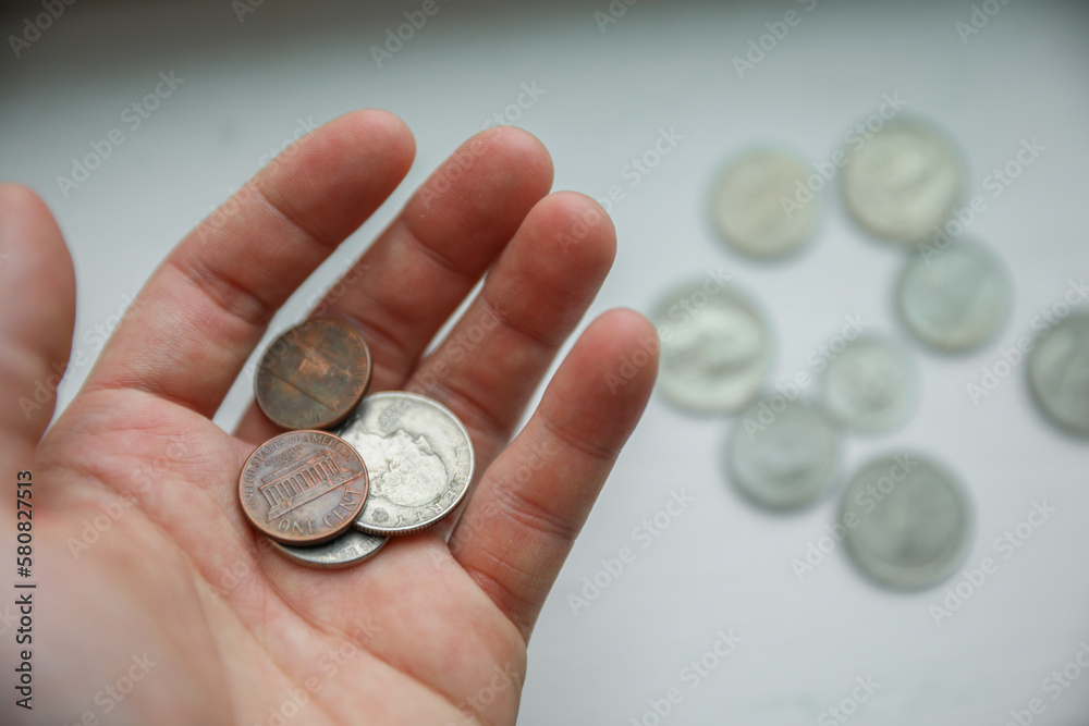 dollar and coins with hand showing the current finance and economy of the us market including the banks depicting savings and loans and the financial struggle to invest and success dollar and coins with hand showing the current finance and economy of the us market including the banks depicting savings and loans and the financial struggle to invest and success