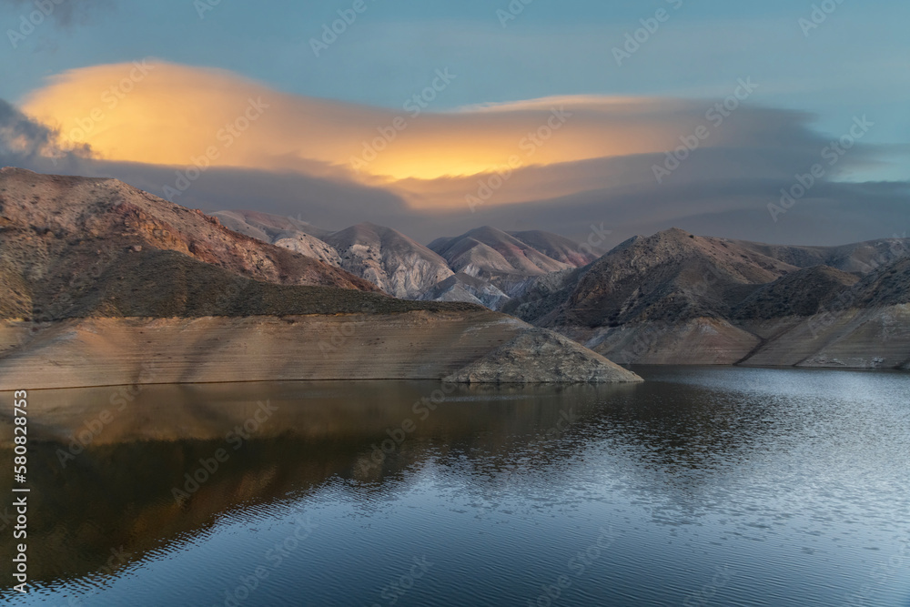 Beautiful sunset over the mountains and lake. Beautiful reflection in the water. 