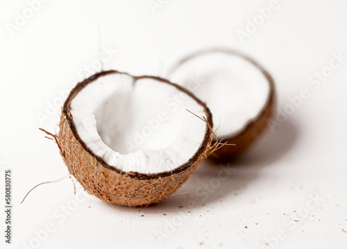 Open coconut halves. Two parts pieces of coco nut fruit with brown shell, ripe flesh