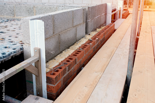 Φωτογραφία Insulating walls of new build houses by placing rock wool inside wall cavities as part of the energy-saving measures