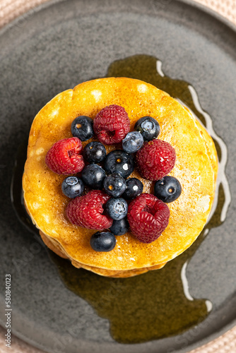 Pancakes with berries and maple syrup stock photo