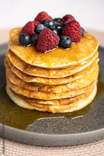 Pancakes with berries and maple syrup stock photo