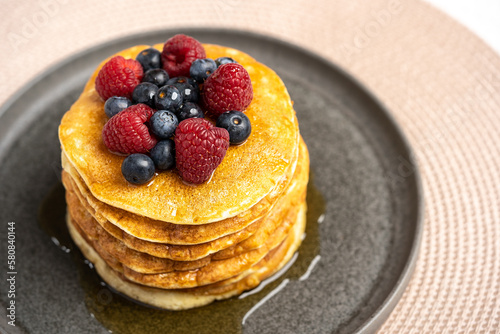 Pancakes with berries and maple syrup stock photo