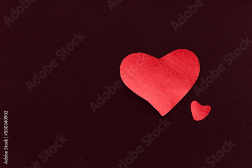 Two red heart on a black background, made of paper, romantic and festive beautiful symbol love