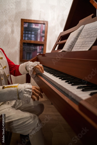 Hands of a man wearing traditional rocco costume from 17th century wearing piano. photo