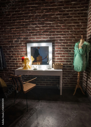 Interior of a back stage or offstage female makeup dressing room consist of wig, mirror, wardrobe and make up stuff photo