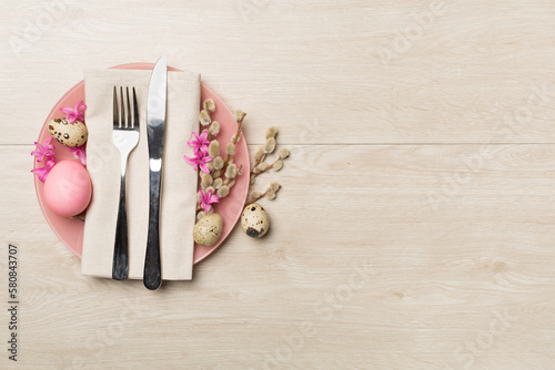 Easter table setting with spring flowers and cutlery on wooden background  top view