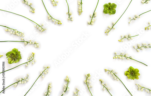 Frame with white flowers Lily of the valley ( Convallaria majalis, May bells, may-lily ), hellebores on white background with space for text. Top view, flat lay