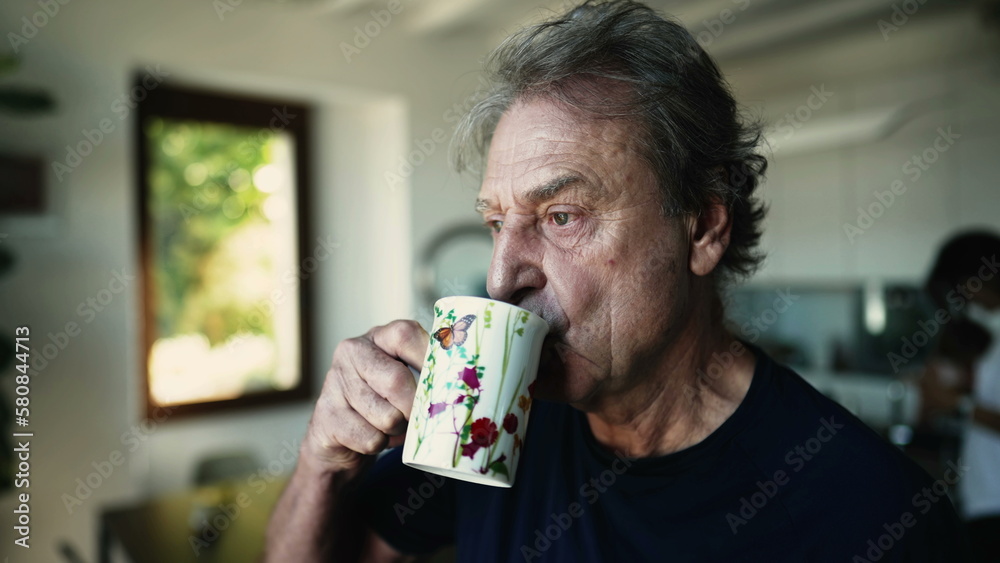 Portrait of a relaxed older man holding cup of coffee or tea