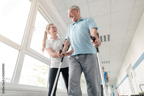 Seniors in rehabilitation learning how to walk with crutches after having had an injury