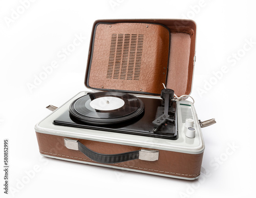 Vintage foldable portable vinyl player with a black sinlge vinyl plate on a turntable. photo