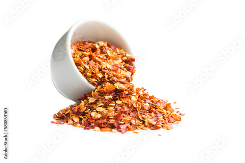 Dry chili pepper flakes in bowl. Crushed red peppers isolated on white background.