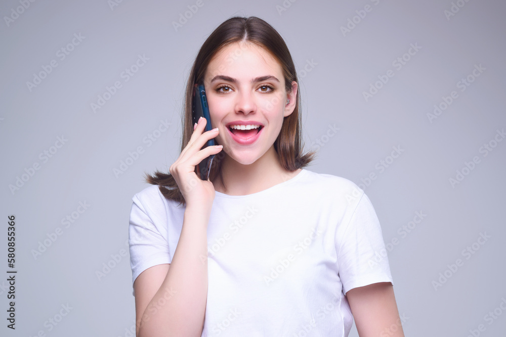 Cute girl using phone device gadget app isolated over studio background. Woman holding a smartphone, chatting by mobile phone. Girl using phone, studio portrait. Woman makes telephone call on phone. Cute girl using phone device gadget app isolated over studio background. Woman holding a smartphone, chatting by mobile phone. Girl using phone, studio portrait. Woman makes telephone call on phone.