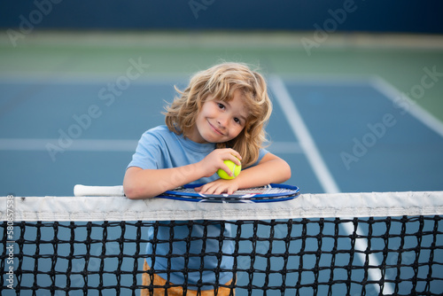 Child playing tennis. Sport child with racket on tennis playground during training in summer. © Volodymyr