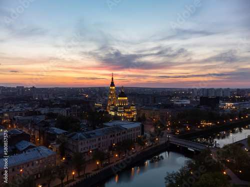 Holy Annunciation Cathedral with lights illumination and evening sunset vivid cloudscape. Aerial Kharkiv city orthodox church in downtown, Ukraine