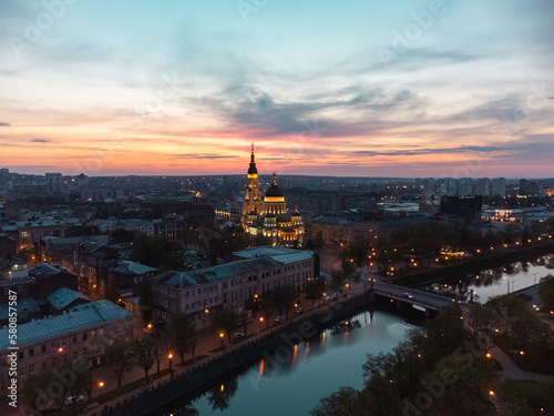 Aerial Holy Annunciation Cathedral with lights illumination and sunset scenic cloudscape. Kharkiv city orthodox church in downtown, Ukraine