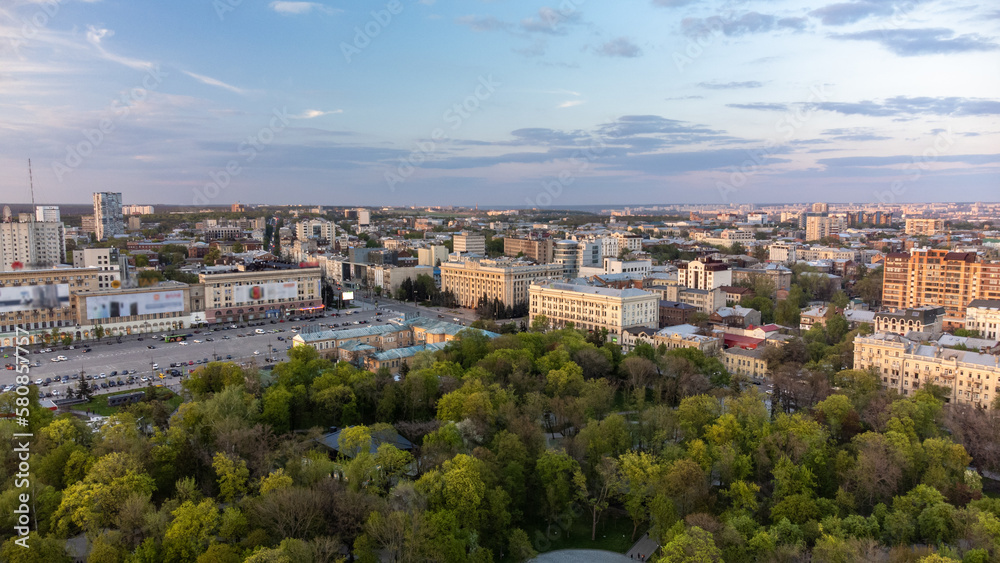Aerial view on Svobody Square and historic buildings from city park with sunset light. Kharkiv, Ukraine in spring