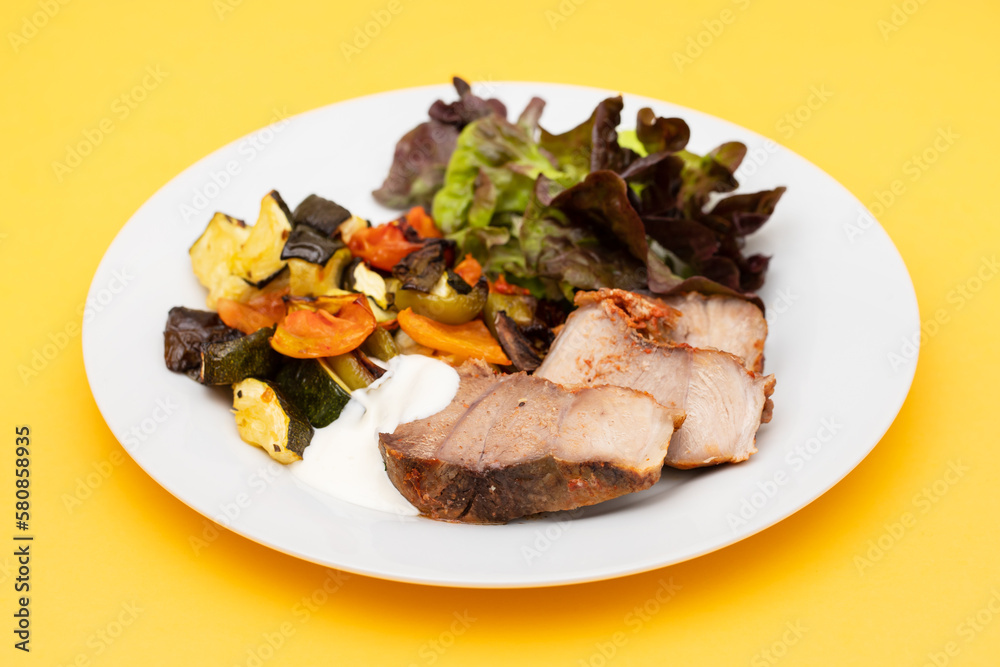 Baked pork with vegetables and fresh salad on plate Baked pork with vegetables and fresh salad on plate
