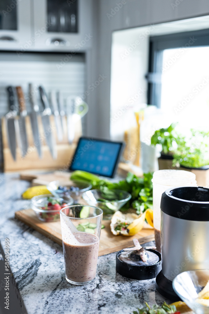 Closeup of smoothie in drinking glass with blender and fruits on kitchen counter, copy space Closeup of smoothie in drinking glass with blender and fruits on kitchen counter, copy space