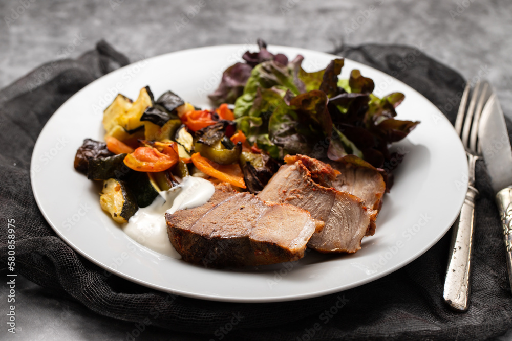 Baked pork with vegetables and fresh salad on plate Baked pork with vegetables and fresh salad on plate