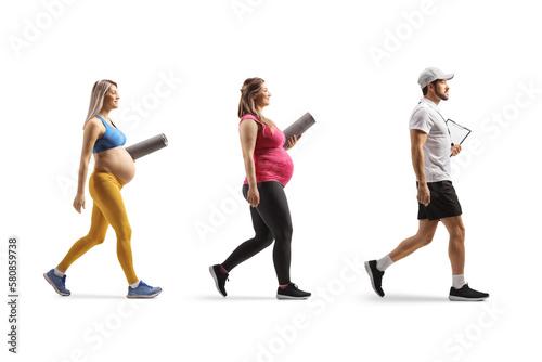 Personal fitness trainer walking with two pregnant women