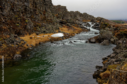petite cascade donnant naissance à une joli rivière au bord d'une montagne et de la faille de Siffra en Islande photo
