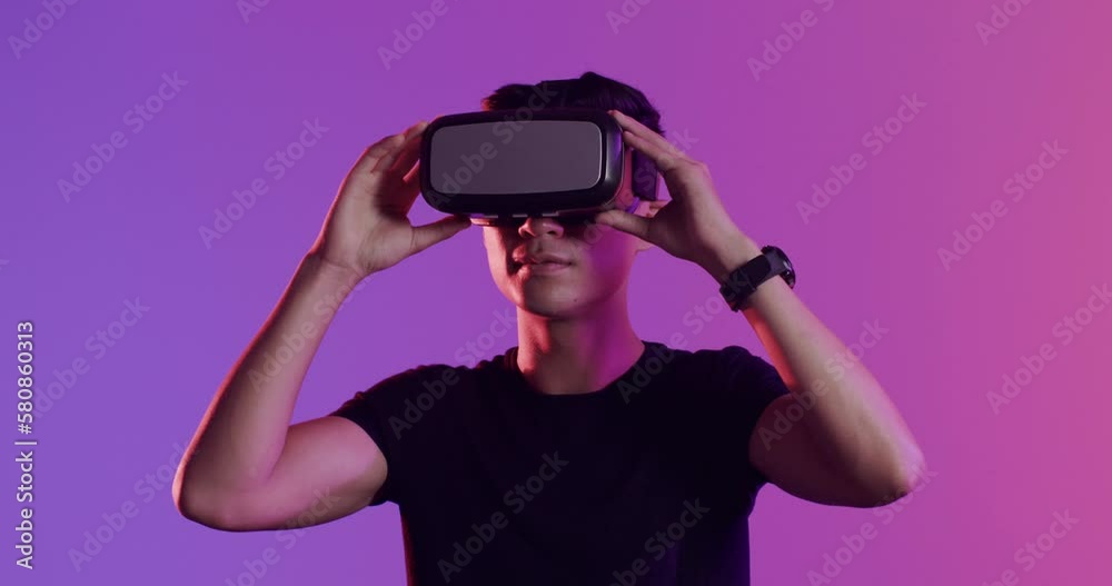 Happy asian man using vr headset on purple background, slow motion Happy asian man using vr headset on purple background, slow motion