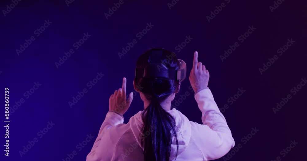 Asian woman using vr headset, touching virtual screen on blue background, slow motion Asian woman using vr headset, touching virtual screen on blue background, slow motion