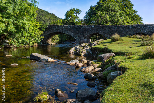 The River Duddon flows under the bridge at the picturesque village of Ulpha on the Sella Brow Road in the Lake DistrictNational Park, England.