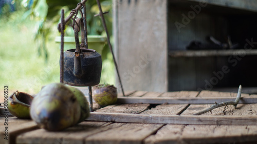  Uma exibi    o art  stica de simplicidade r  stica - uma mesa de madeira antiga envelhecida adornada com um coco fresco e uma chaleira vintage  evocando uma sensa    o de calma e relaxamento em um ambiente