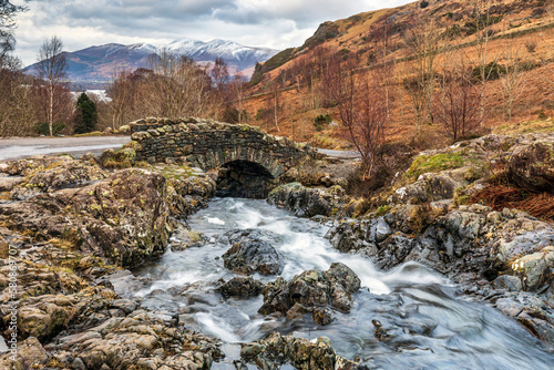 Foto Ashness Bridge, with the snow covered mountain of Skiddaw in the distance, near Keswick and Derwent Water in the Lake District National Park, England